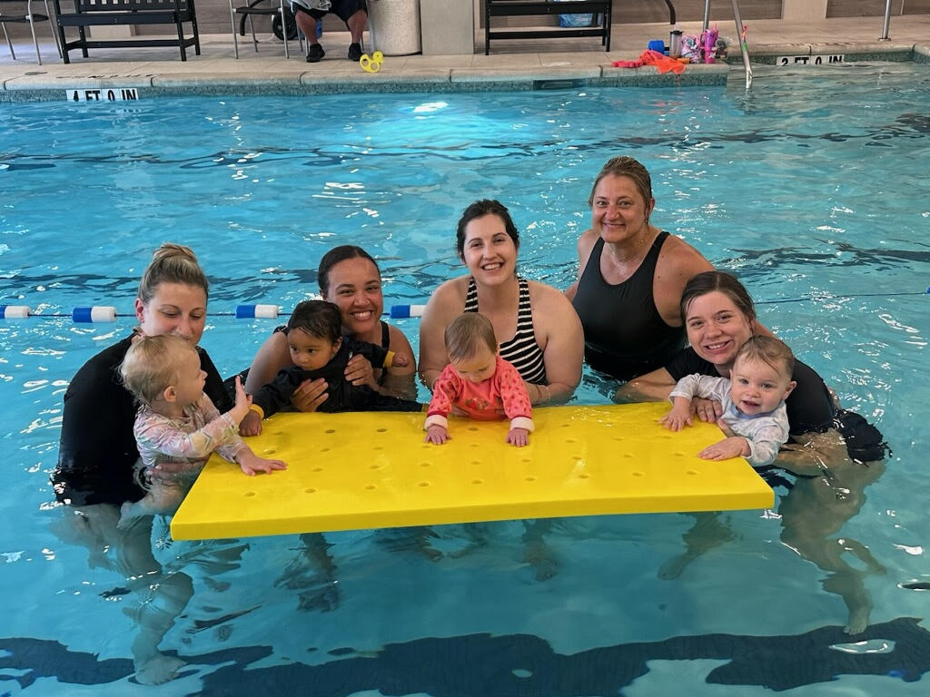 Coach and young swimmer singing together during a lesson
